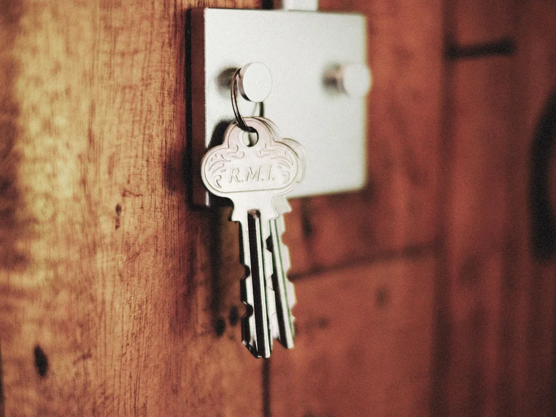 A set of house keys left hanging in a door lock