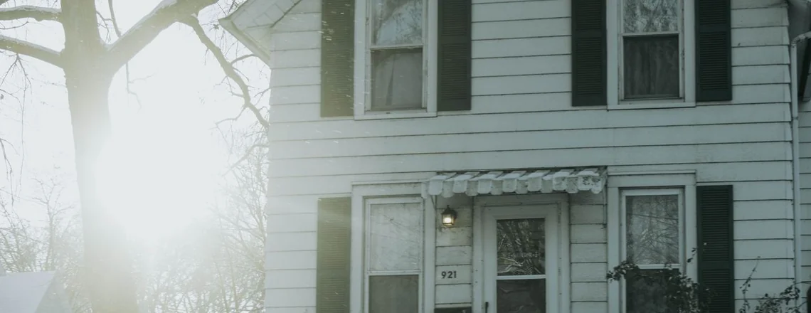 A modest older two-story single-family house on an ordinary Detroit street in winter, the kind of home most affected by property tax foreclosure