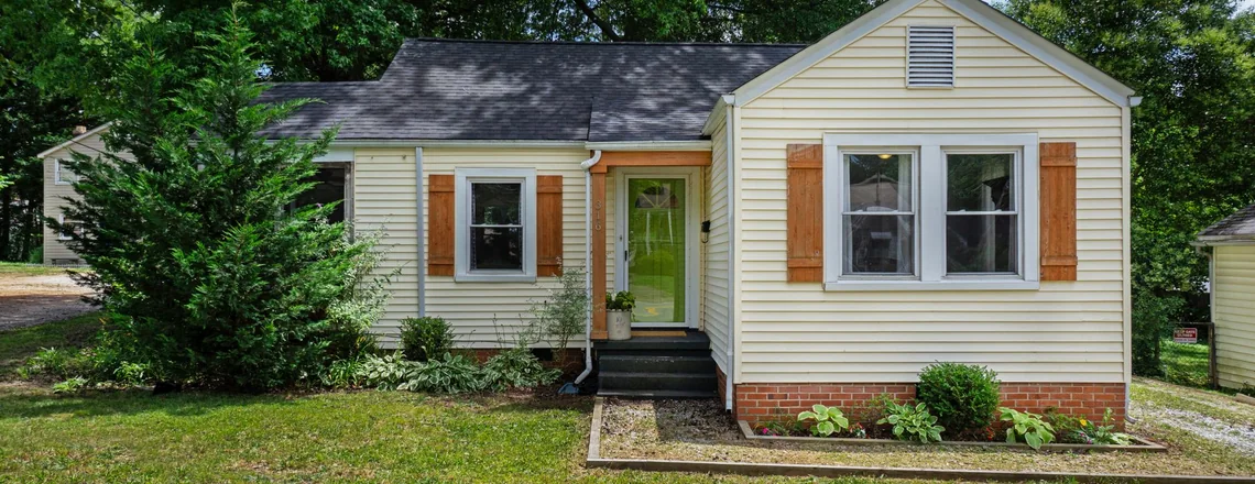 A modest single-story house with a plain front yard on an ordinary Houston, Texas street