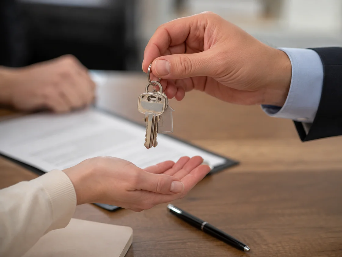 House keys handed across a closing table, the back taxes paid off out of the sale proceeds