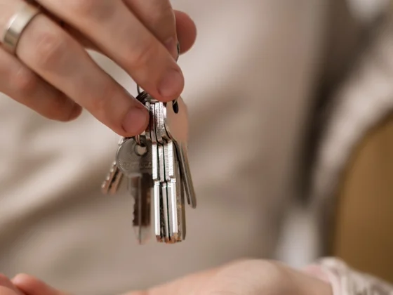 A homeowner handing over house keys after selling a Detroit house as-is