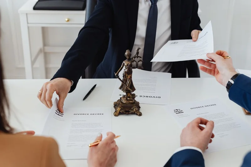 A couple and their attorney reviewing a divorce decree that divides the marital home