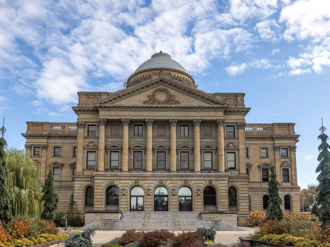 A county courthouse with stone columns under a blue sky, the kind of building where judicial foreclosure cases are heard