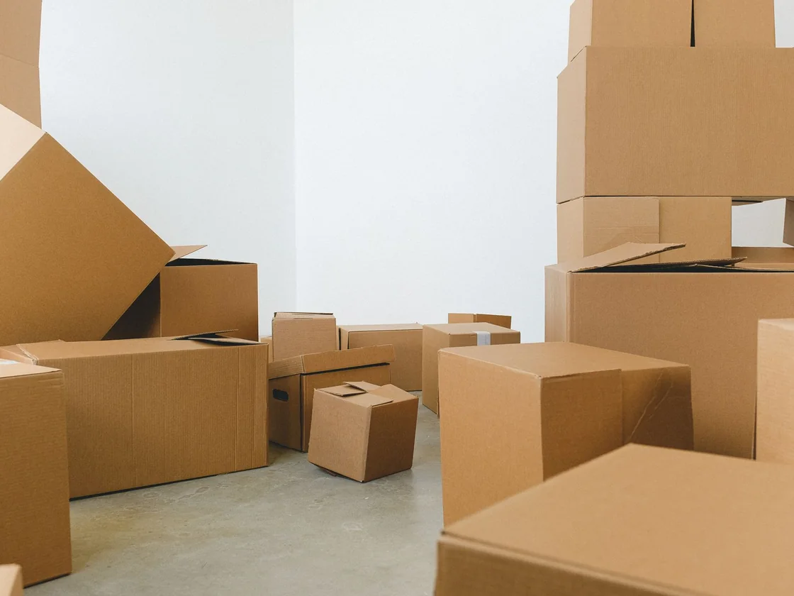 Cardboard moving boxes stacked and scattered across the bare floor of an empty room