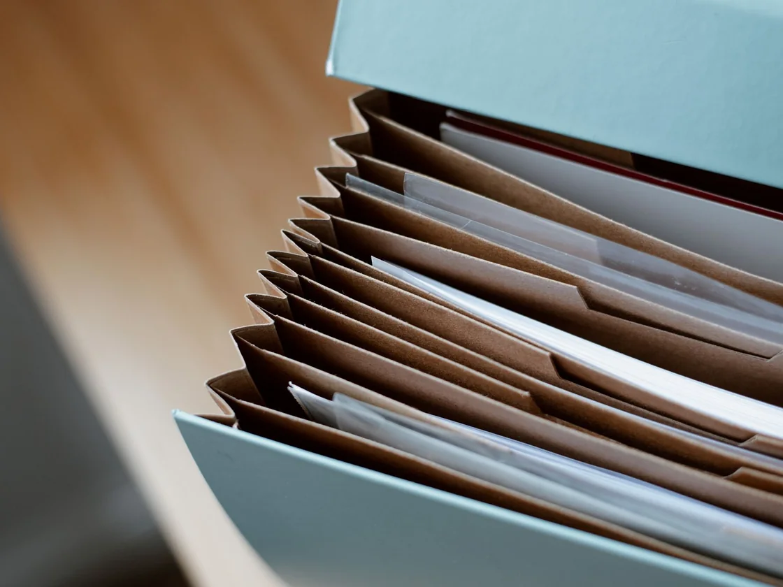 An accordion file of documents open on a table, the lease and rent records a buyer asks for