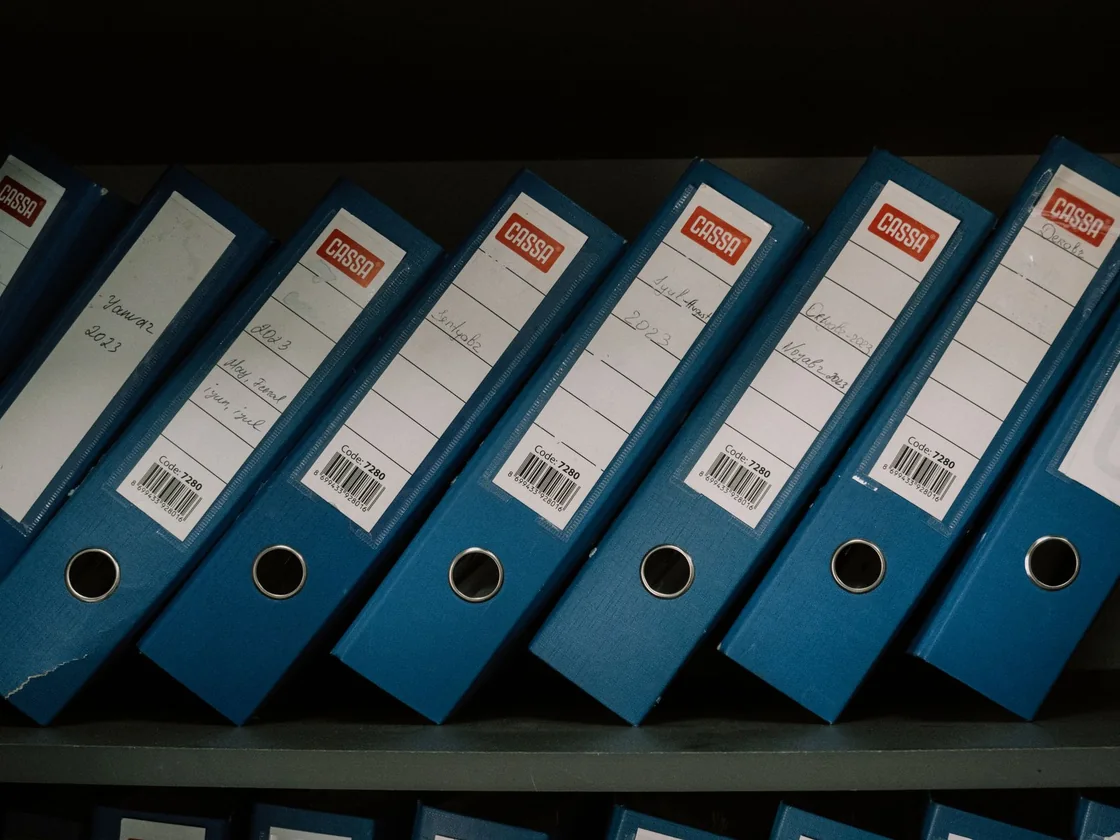 A shelf of labelled archive binders holding building and permit records