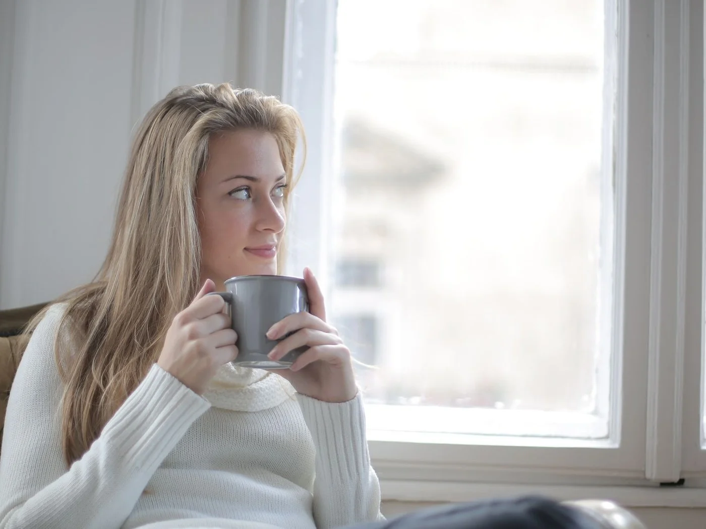 Woman having a quiet coffee by a bright window