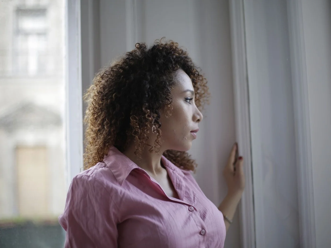 Woman standing by a window, thinking things through
