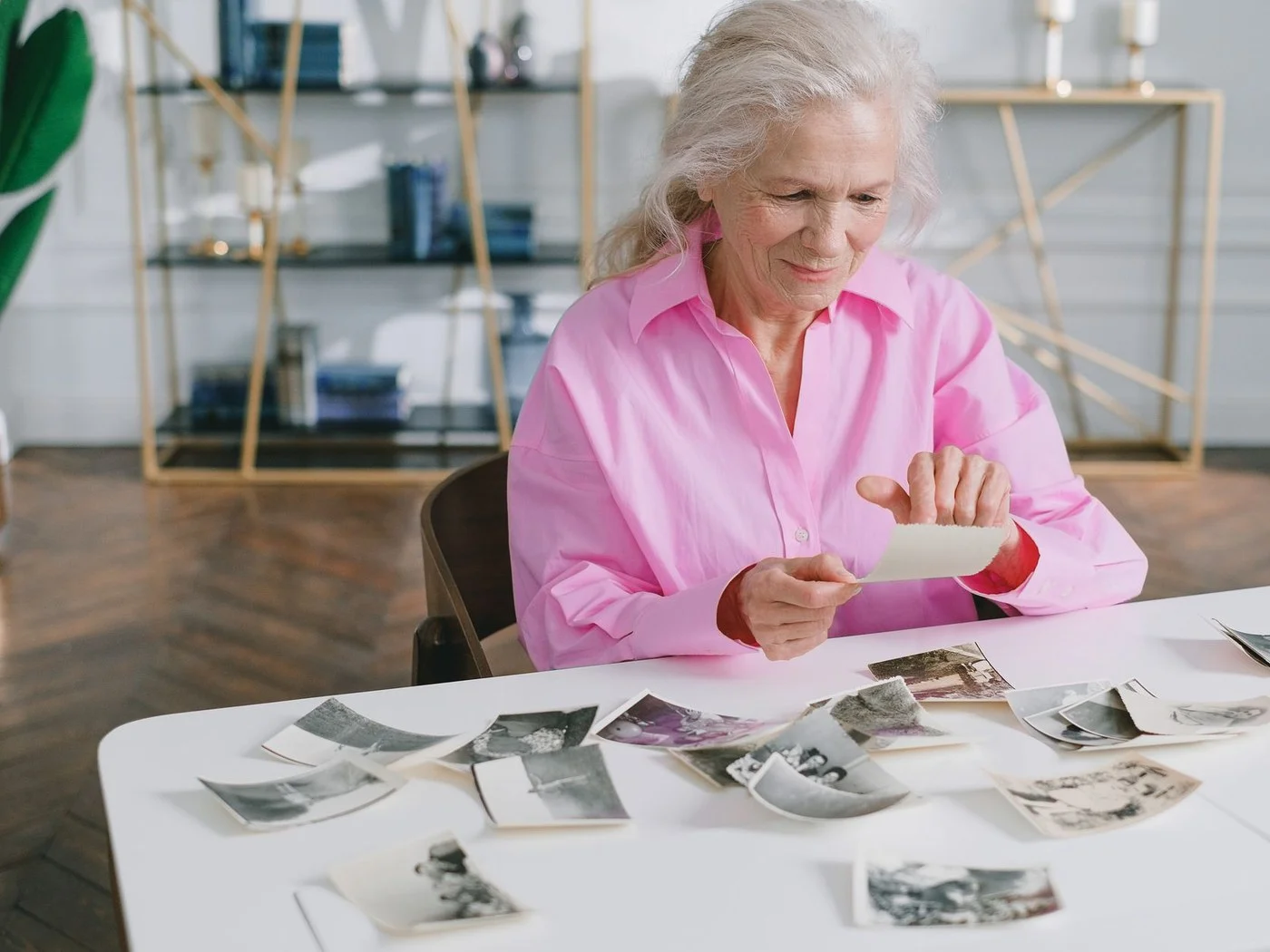 Senior woman at a table looking through old family photographs