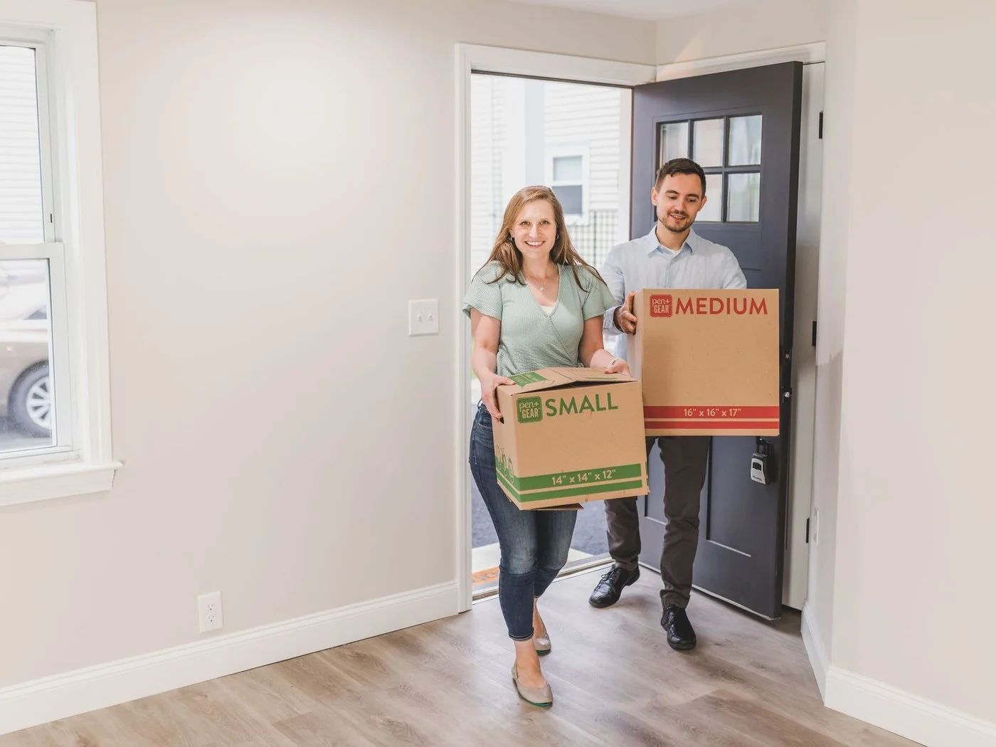 Couple carrying boxes into their new home